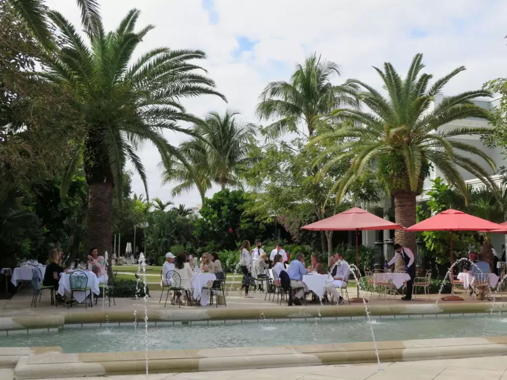 Colorful umbrellas, canary palms, and fountains at Sant Ambroeus restaurant in Royal Poinciana Plaza.