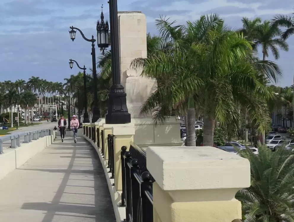 Two people riding scooters on Flagler Memorial Bridge.