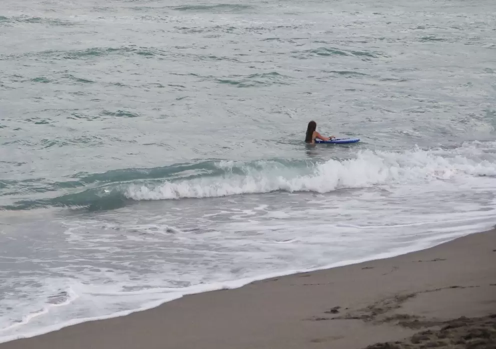 Girl with a bodyboard near the shore.