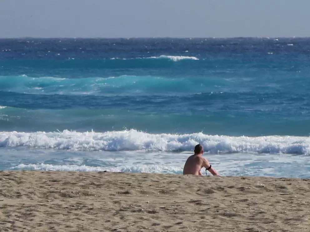 A bodyboarder checks out the water with its amazing colors.