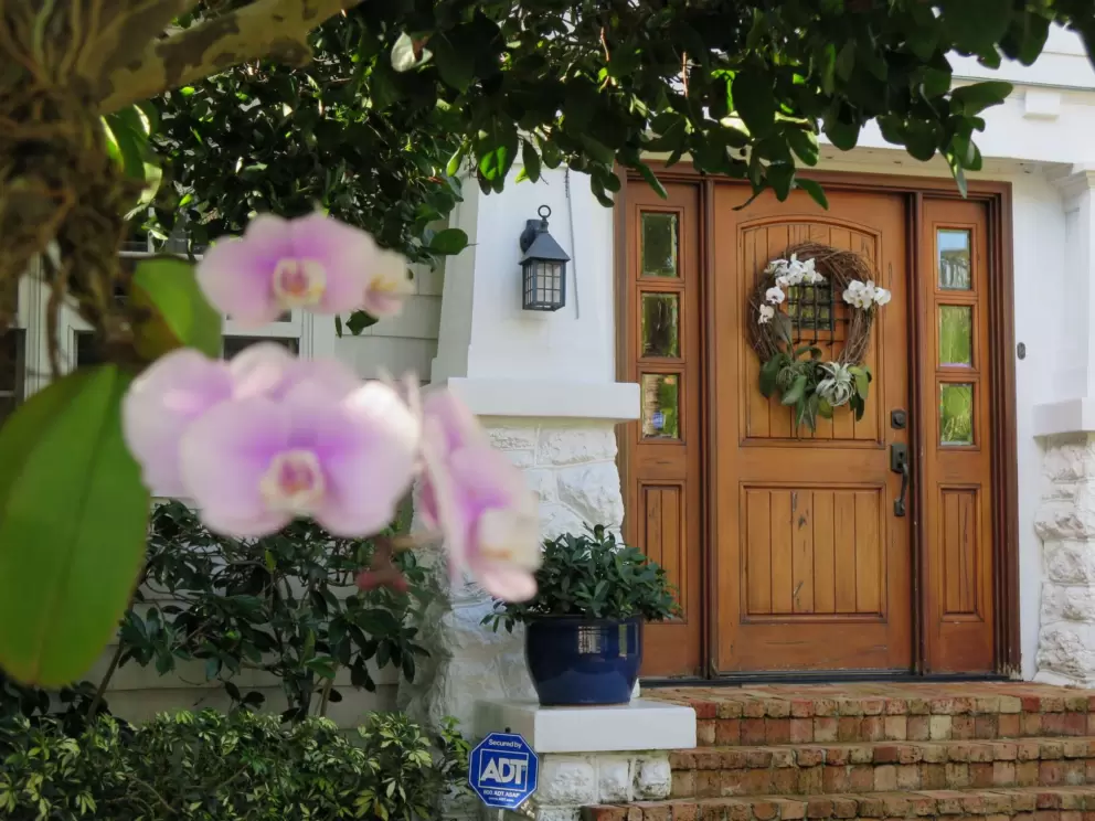 Wooden doorway with orchids and blue pot.