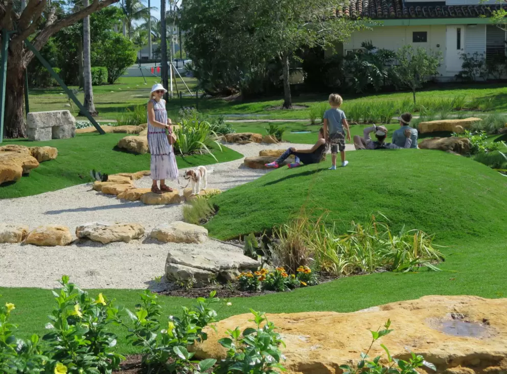 Flowers and boulders beautify the area of little hills that kids love to run on.