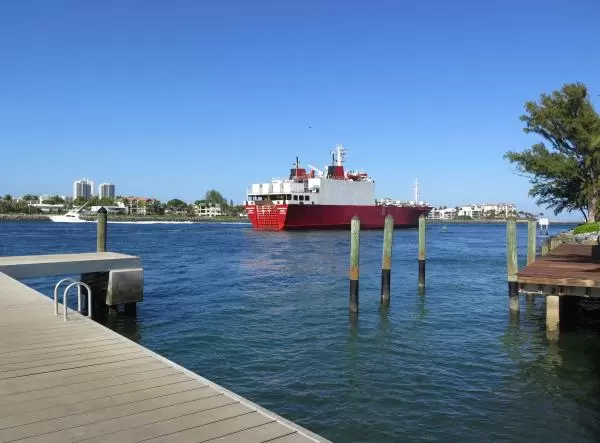 Dock, Riviera Beach neighborhood, fishing boat, and ship exiting the inlet.