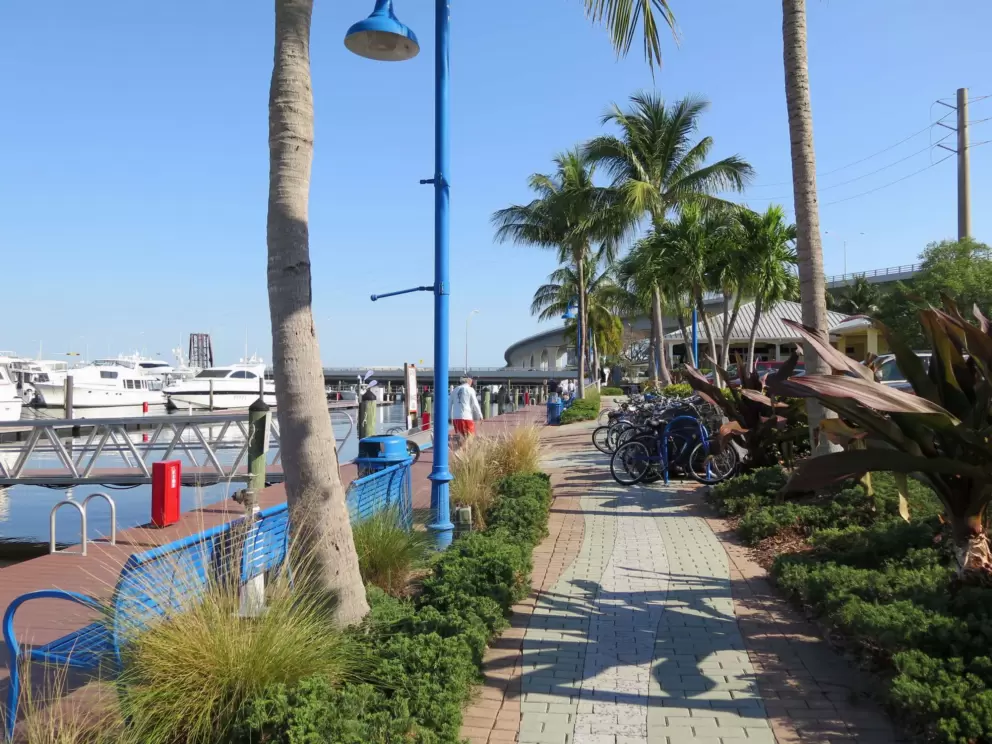 Bikes, blue benches, lampposts, and brick paving at Sunset Bay Marina, where the boardwalk ends. 