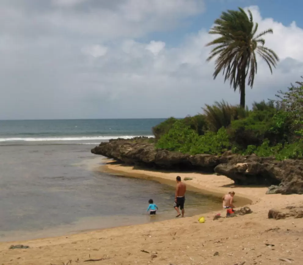 A local family explores a sheltered corner of the beach.