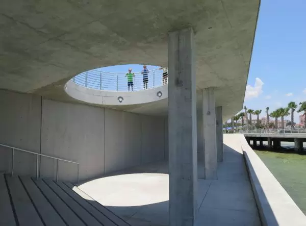 Kids look down from the hole in the concrete.