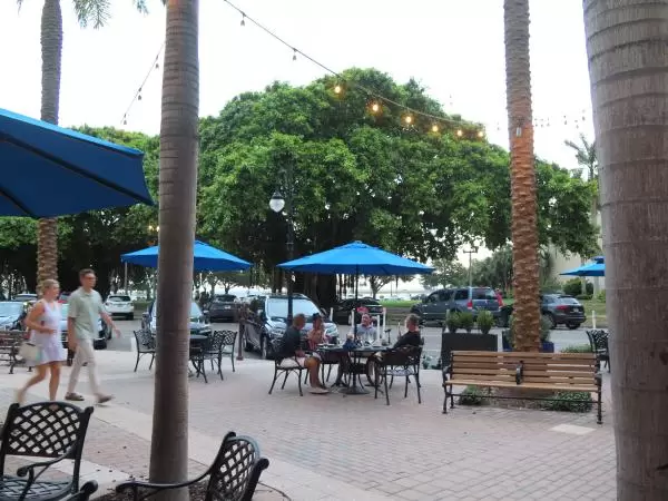 A couple walks along under the strung lights by the cafes on Beach Drive.
