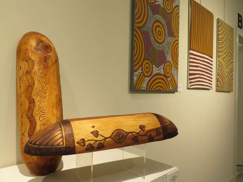 Wood coolamon bowl, and Aboriginal-style [paintings, at Lighthouse ArtCenter Gallery.