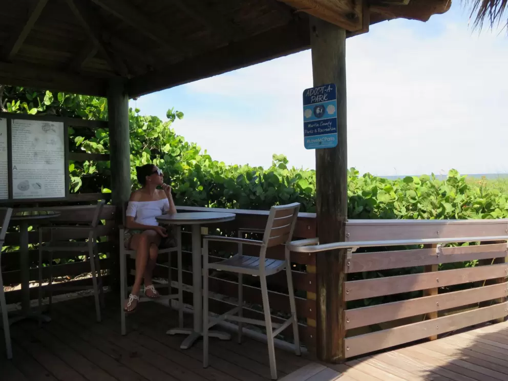 A lady sits at the Seaside Cafe beach concession shack.