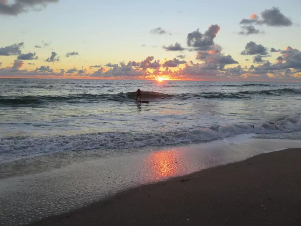 Riding a wave at sunrise.