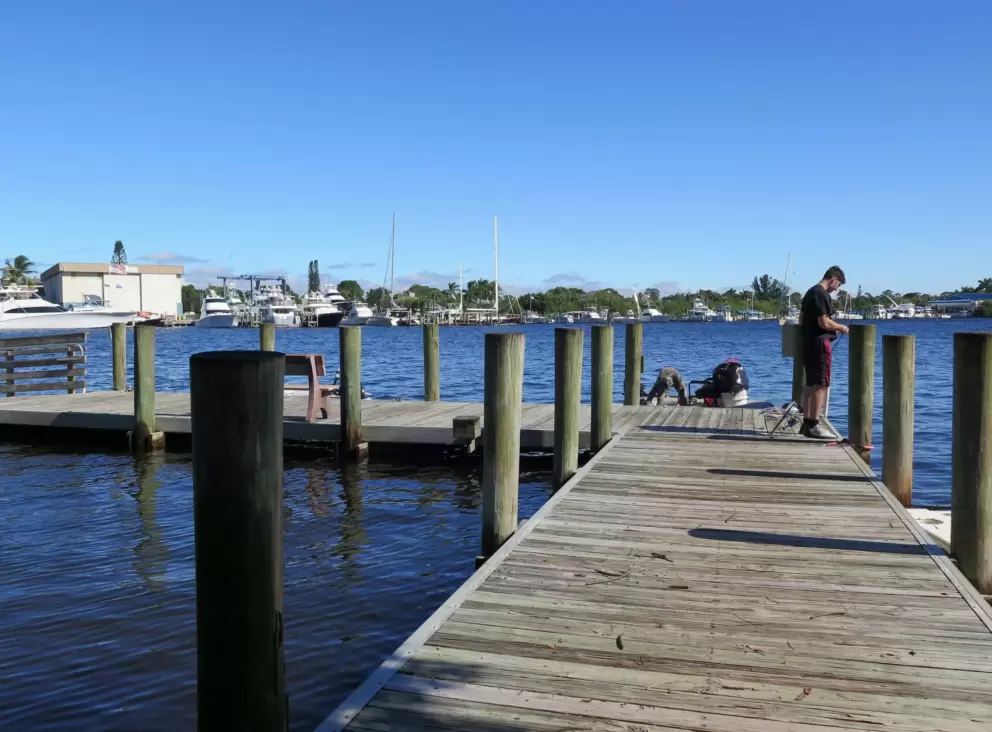 A teenage boy fishes at the dock at Pirates Cove Marina.