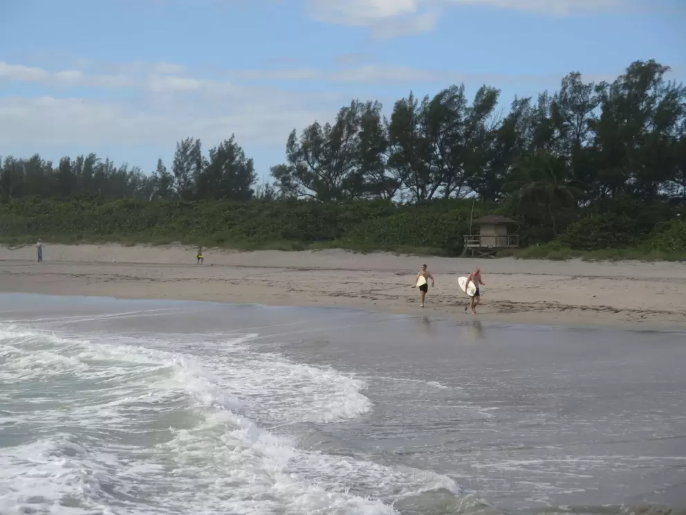 Two surfers head for the water.
