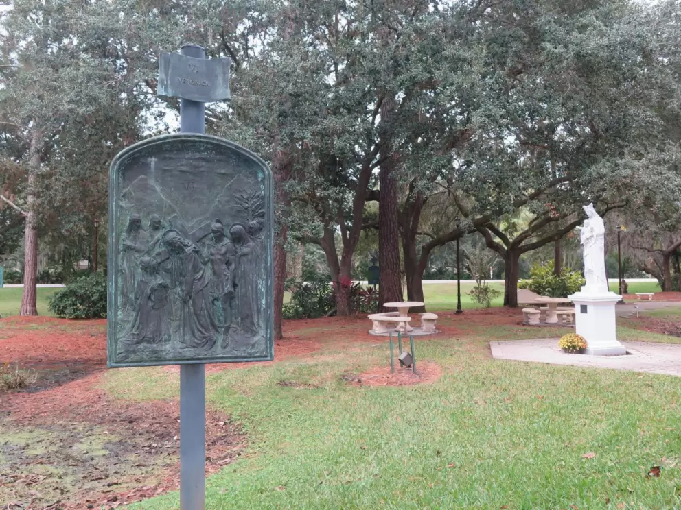 Stations of the cross and a statue of Mary.