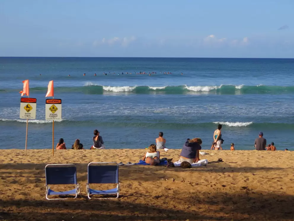 Beachgoers watching the Haleiwa Challenger surf contest in November 2021.