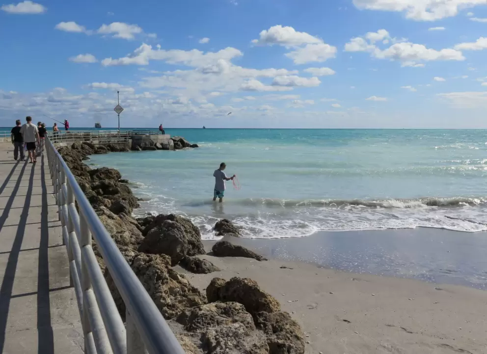 Fisherman casting his net beside the jetty.