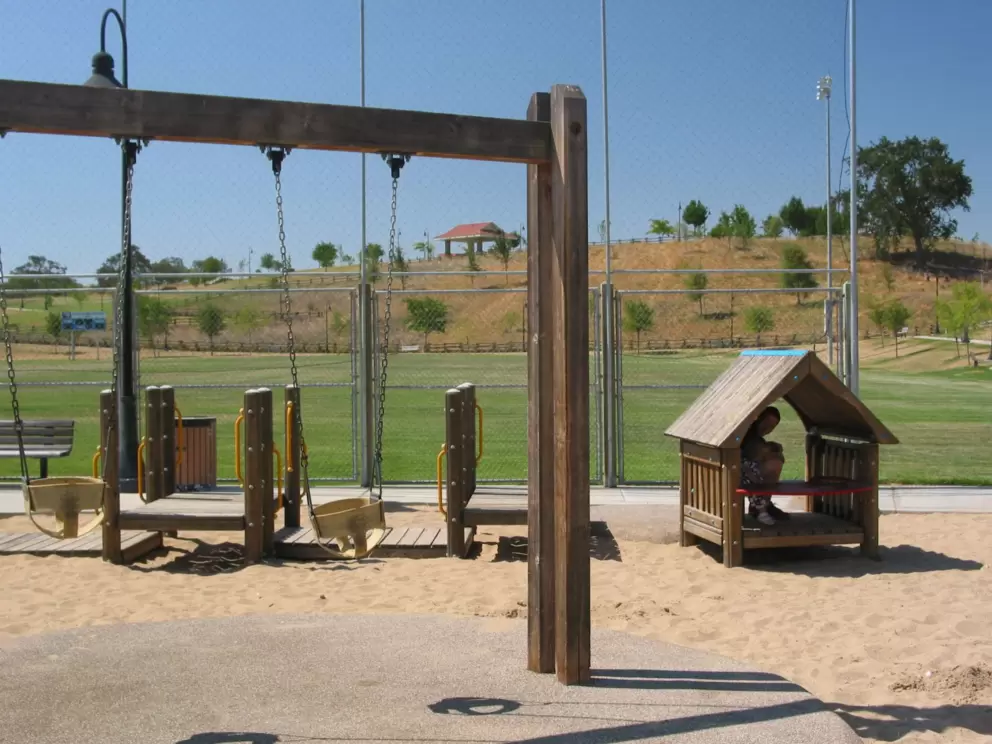 A cute little house providing welcome shade, plus baby swings.
