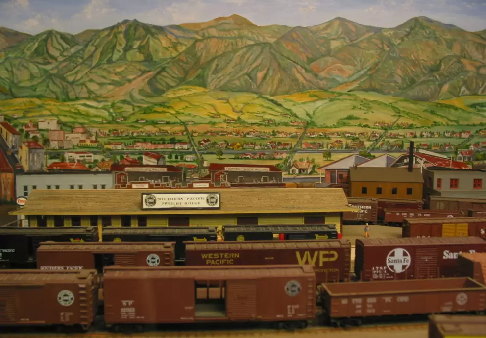 The model railroad with painting of State St and the Santa Ynez mountains behind it. 