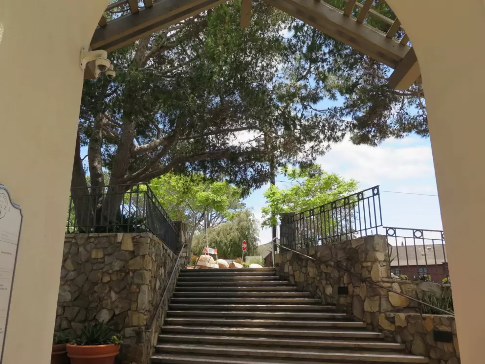 Archway with stone wall and trees.