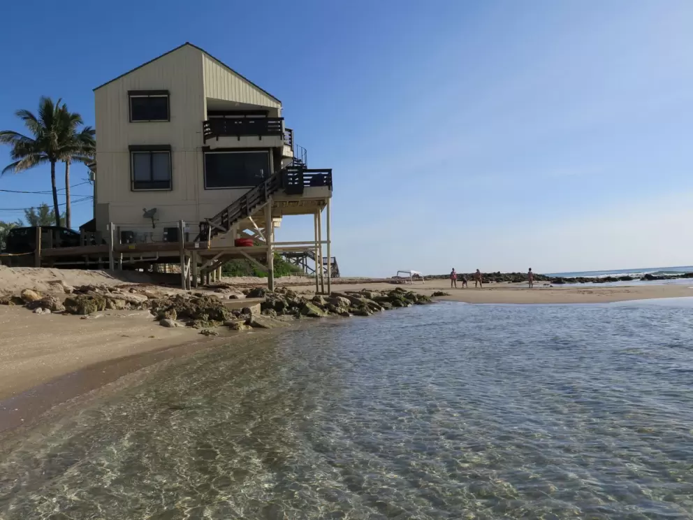 Crystal clear water in front of a beach house.