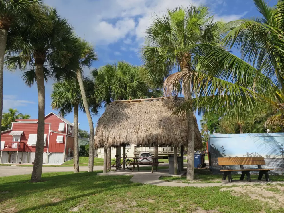 Grass hut and red wooden historic building.