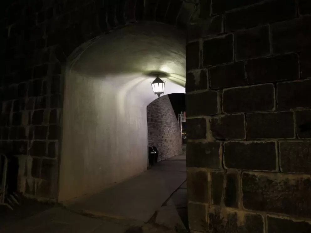 Pedestrian tunnel through St. Louis Gate at night.