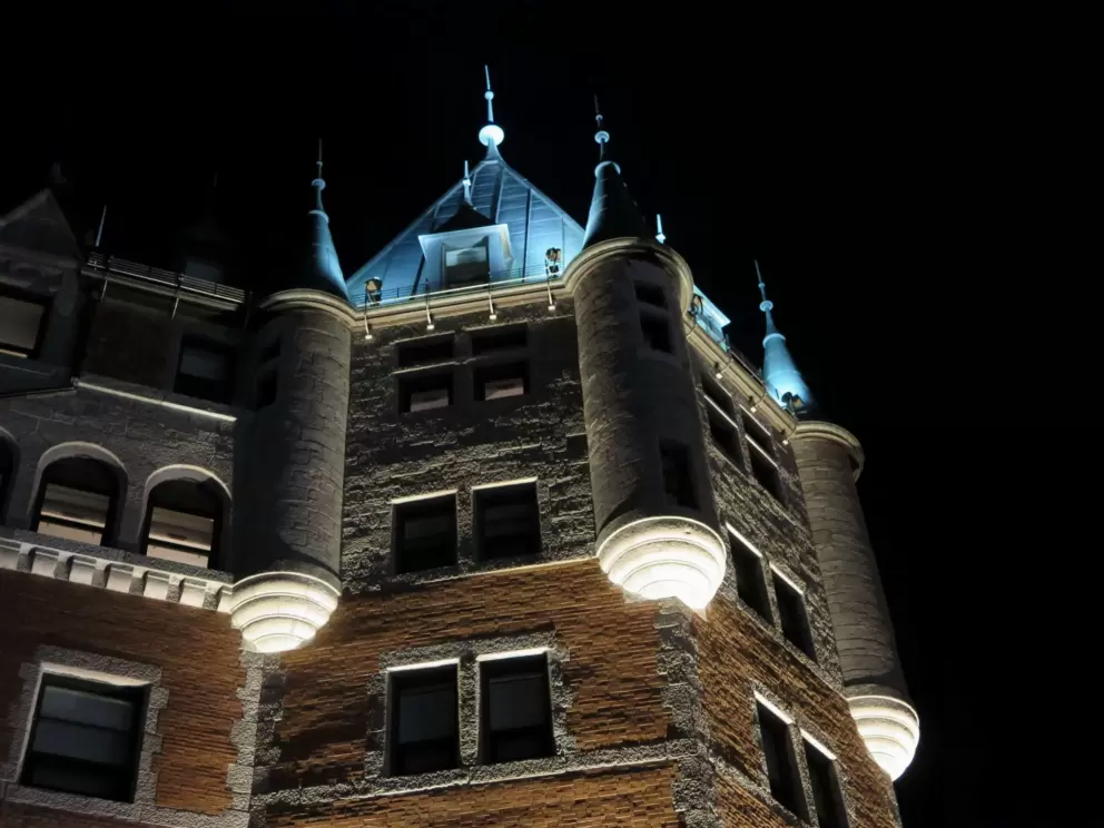 The three towers on the side of Chateau Frontenac, at night.