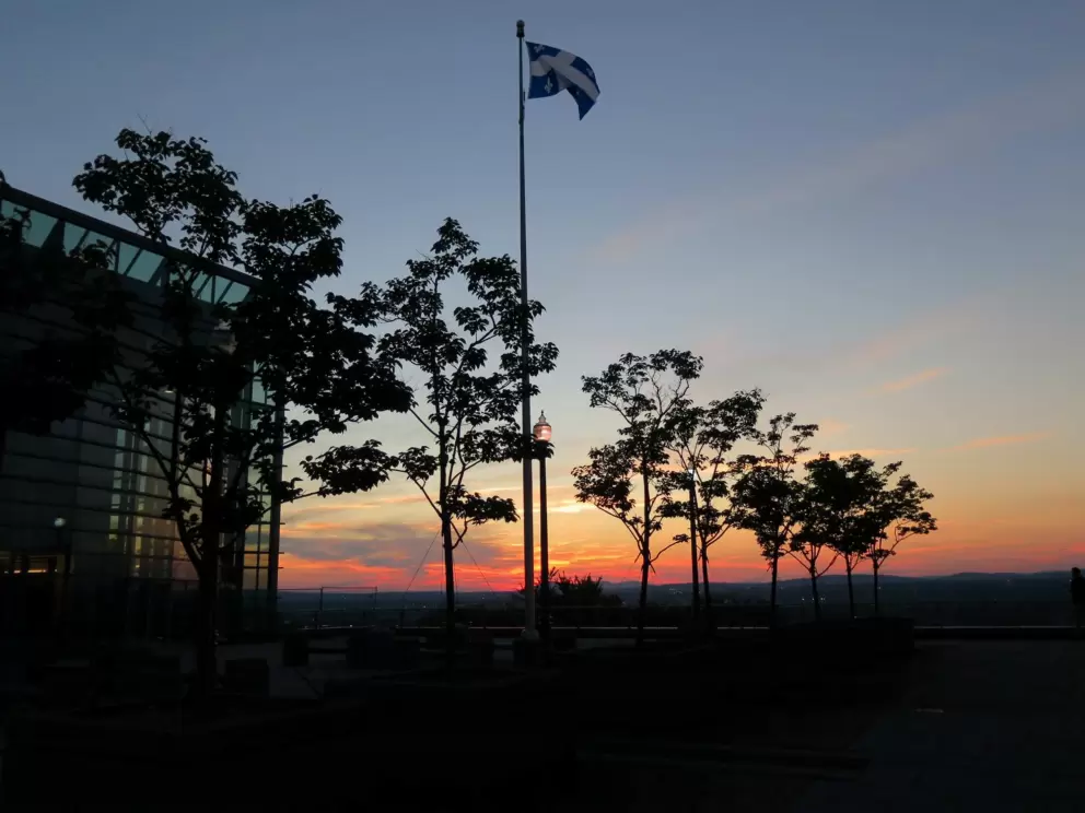 Hilton Quebec with its flag and sunset views over the city. 
