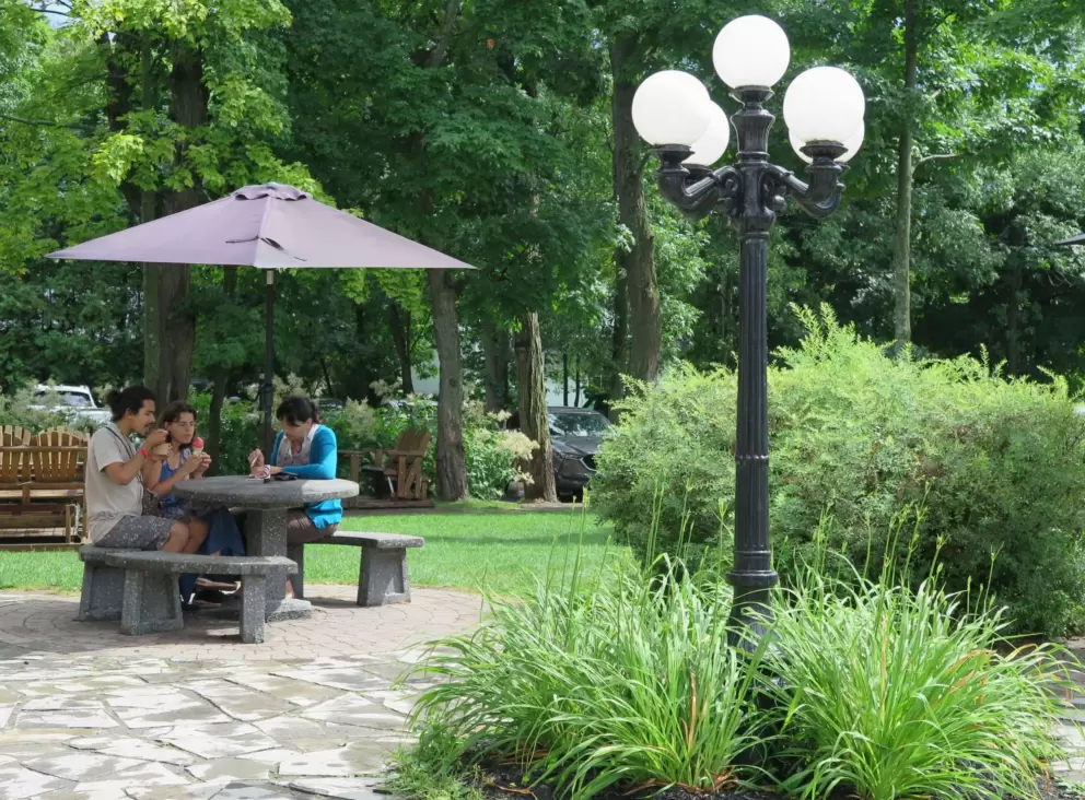A family enjoying their ice cream at a picnic table in the gardens of the chocolaterie. 