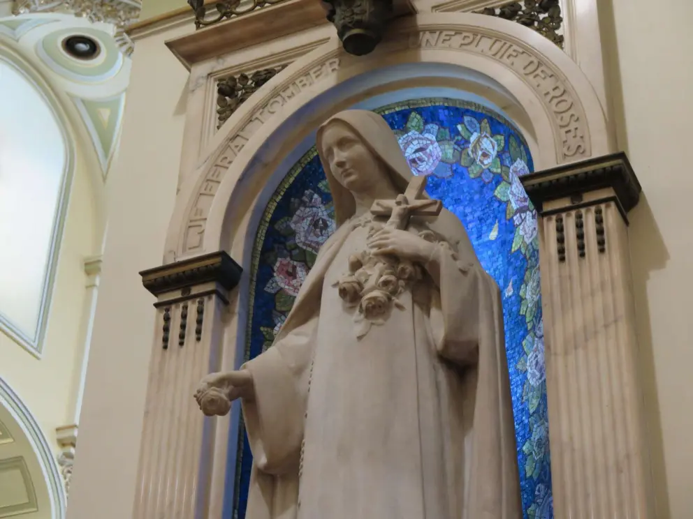 Mary with blue flowers behind her.
