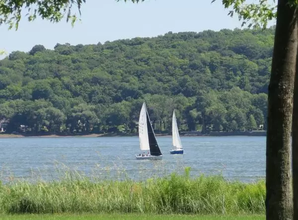 Sailboats go by. 