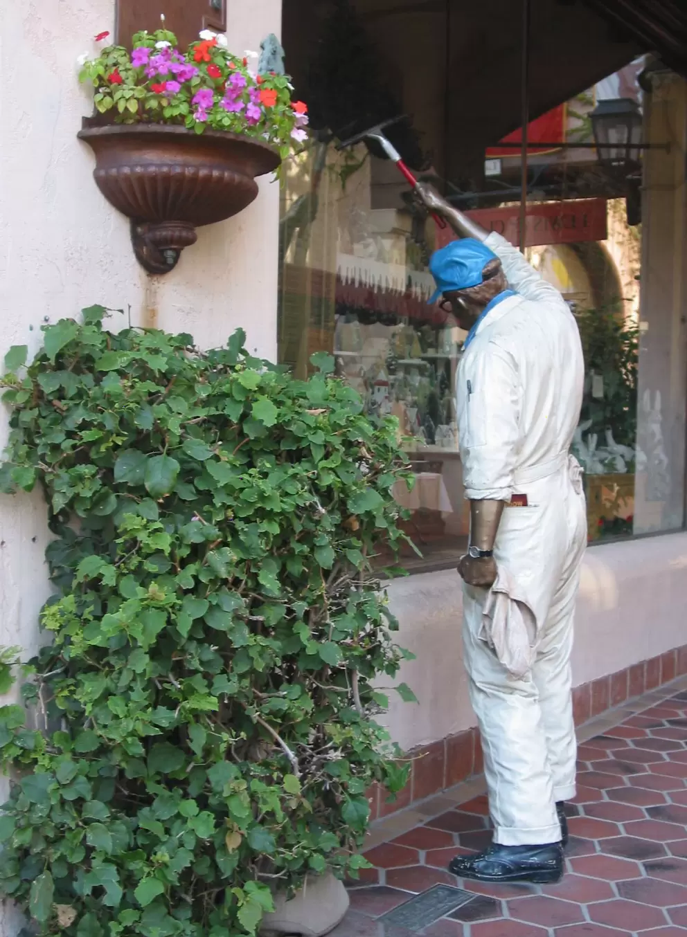 The incredibly lifelike sculpture of a man cleaning the real store window!