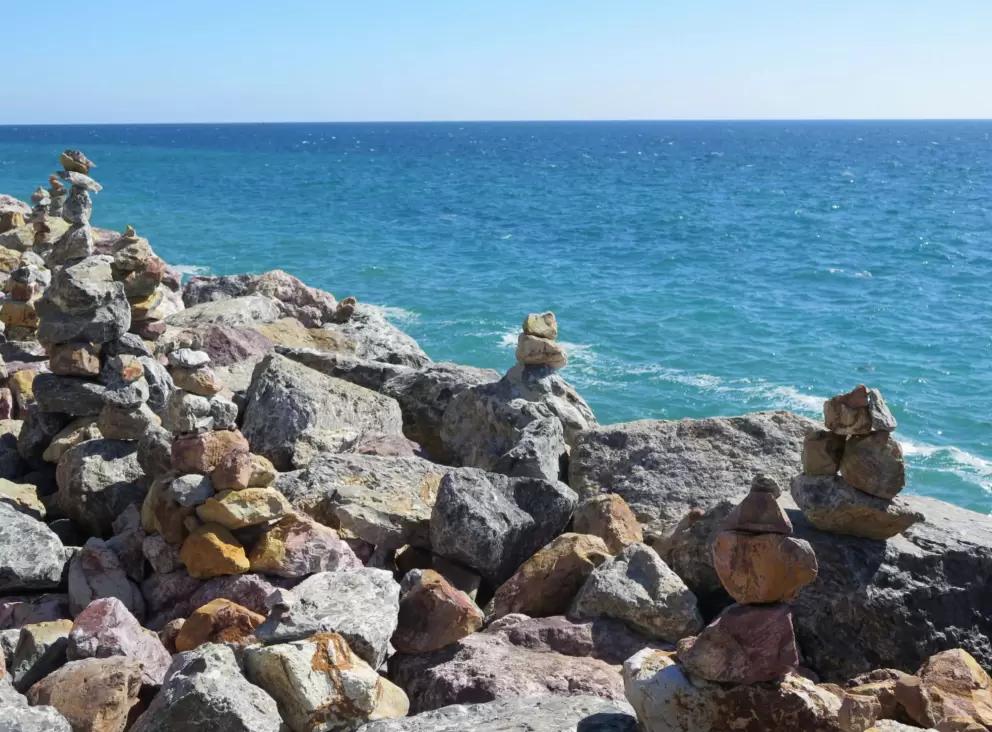 The sea looks beautiful behind the rock cairns. 