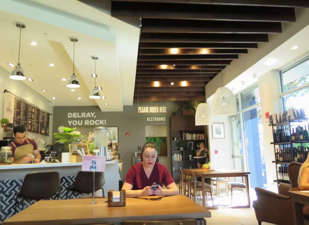 The beautiful plants and dark wood ceiling in Carmela Coffee Bar. 