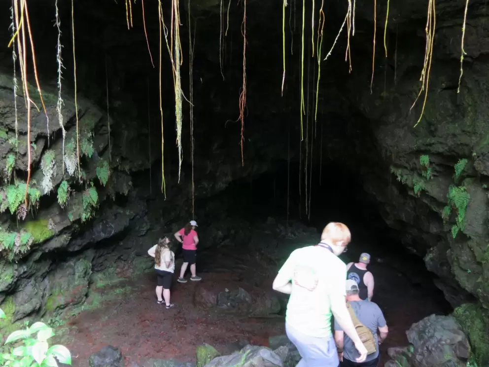 Visitors stepping down rocks to get into the cave. 