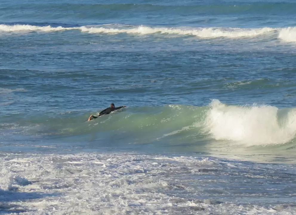 Surfer paddling out. 