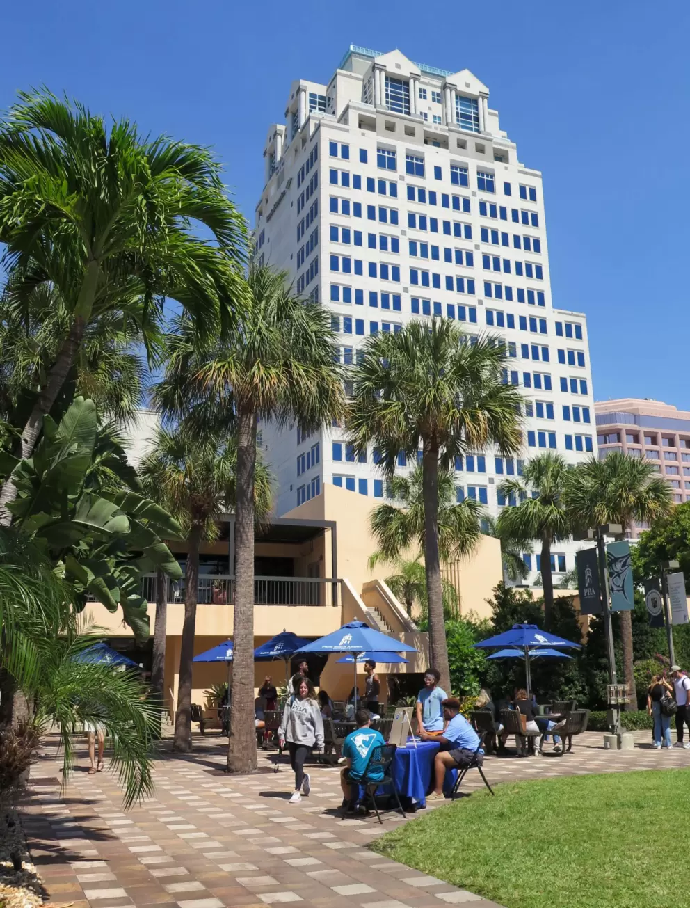 Students sitting outside at Lassiter Student Center, with a beautiful skyscraper behind. 
