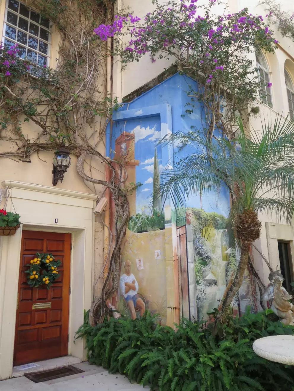 Mural of an old man, a bell tower and bright blue sky. 