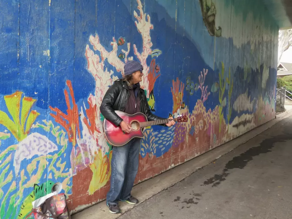 Musician in the tunnel, and coral reef mural. 