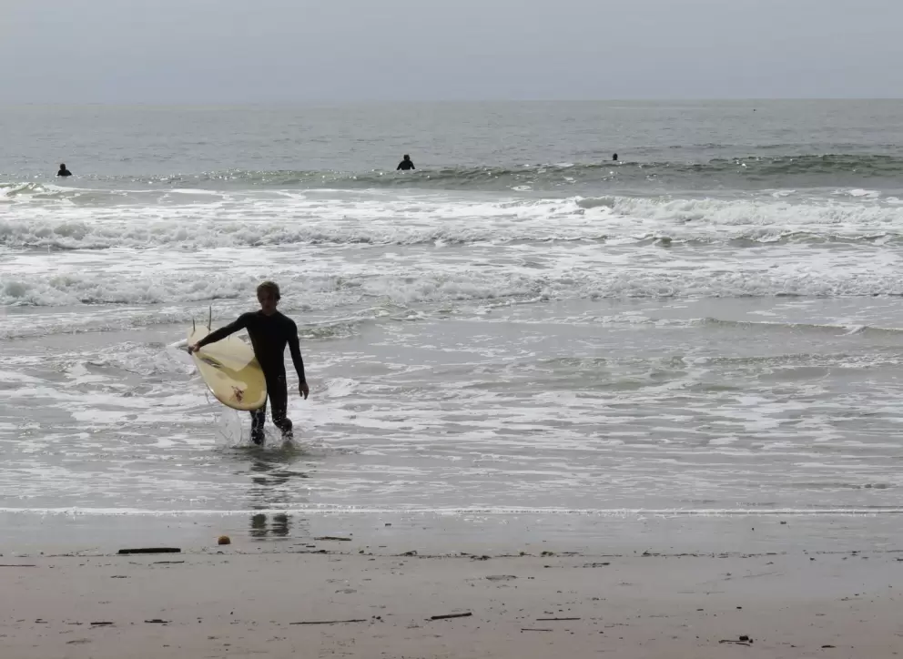 A surfer entering the water. 