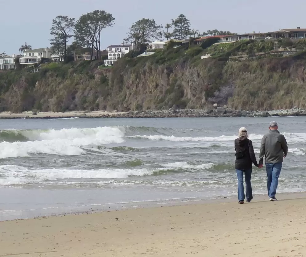 A couple walks along the shore. 