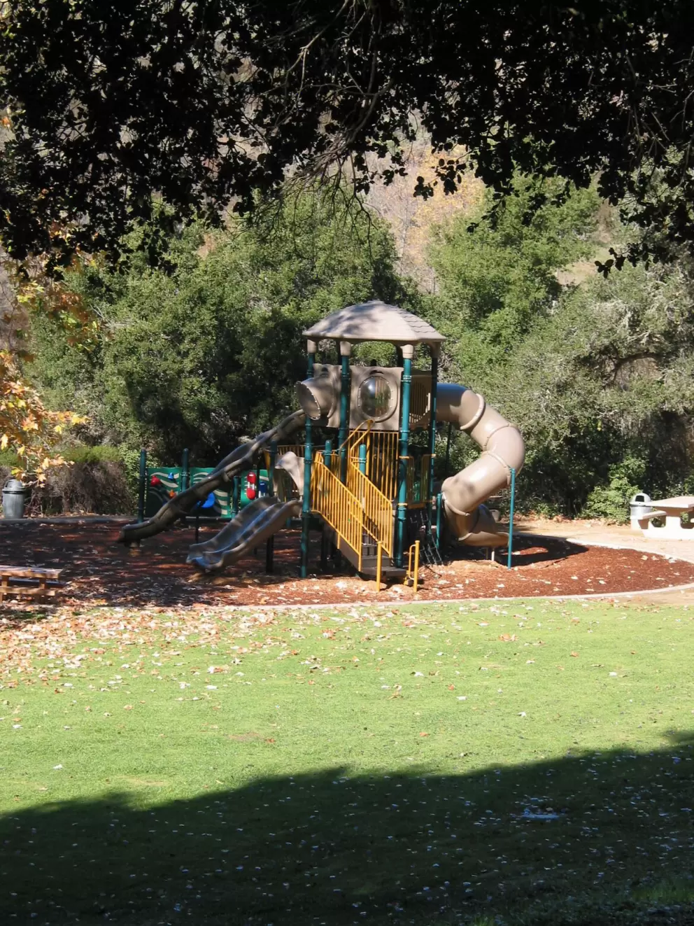 The playground among trees. Check out the huge curved tunnel slide!