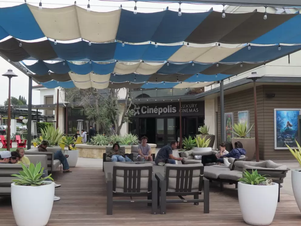 People hang out on the shaded couches outside Cinepolis. 