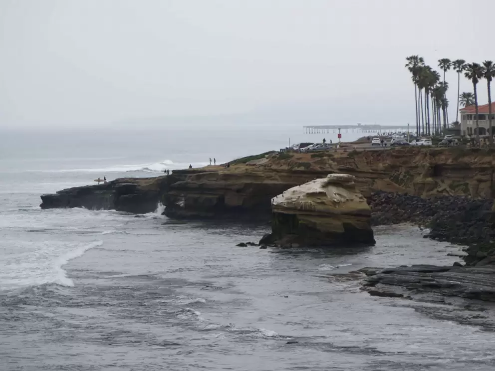 Surfer on the end of a headland. 