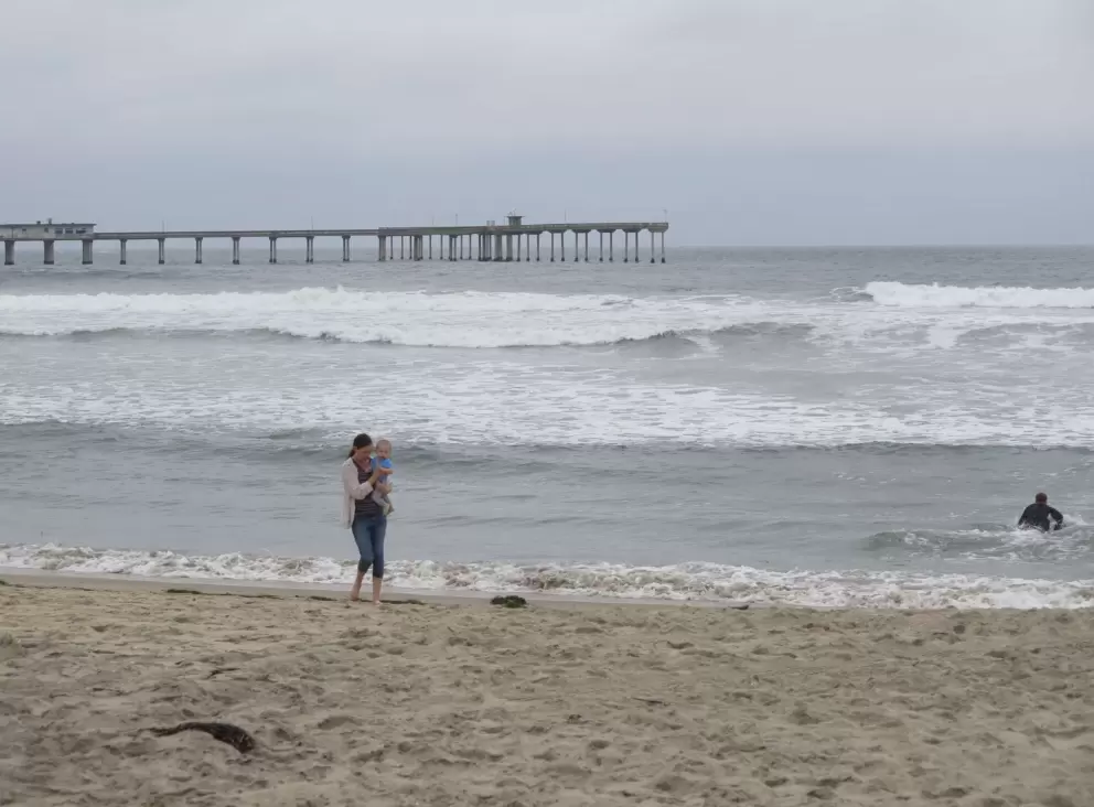 Mother and baby walking near the shore. 