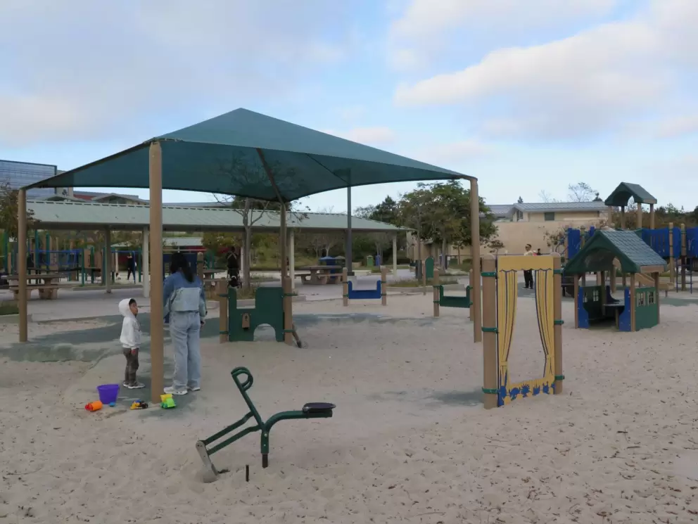The playground, with sand scooper, puppet stage, play house, and window and arch to crawl through. 
