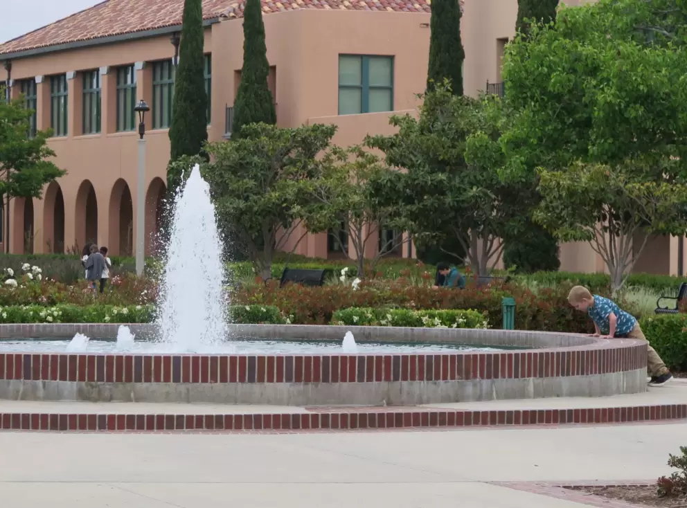 A boy checks out the fountain. 