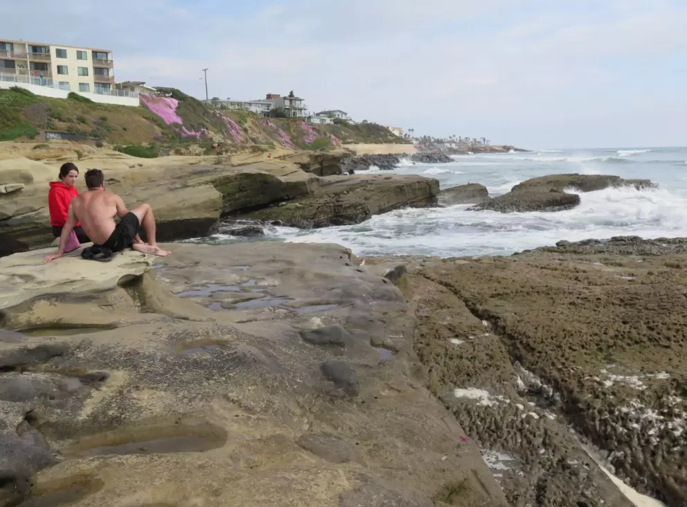 Guys talking on the rocks. 