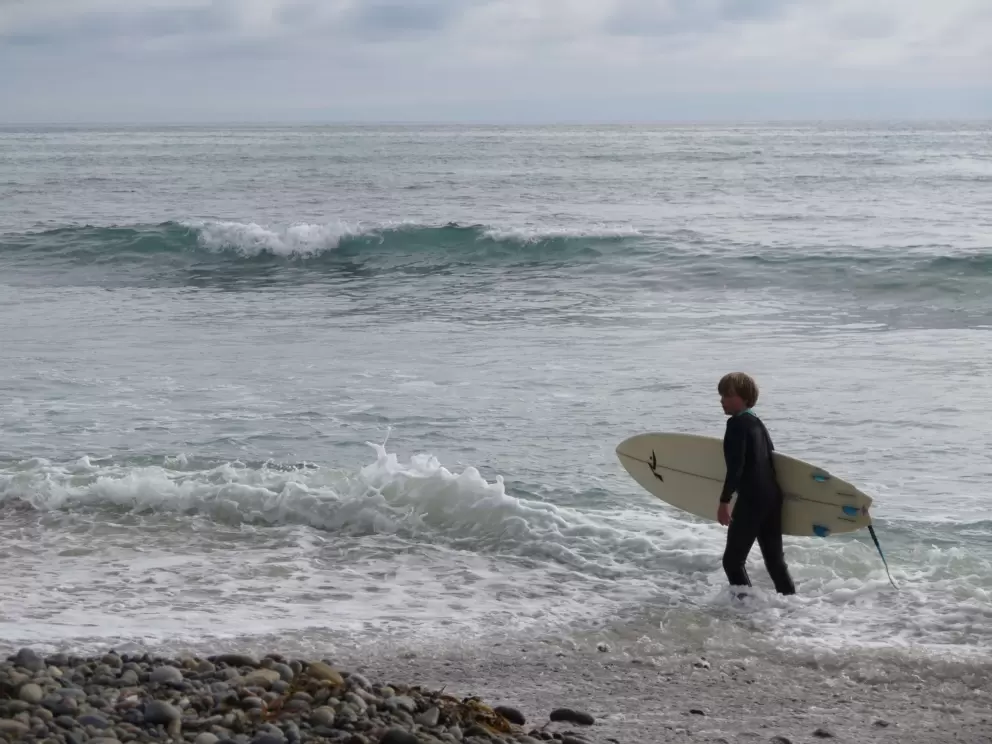 A young surfer heads out. 