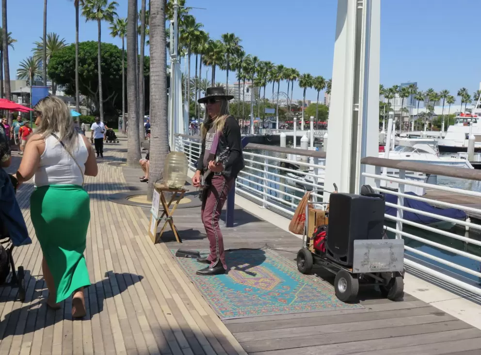Busker and visitors walking by. 