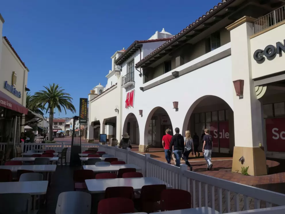 Teens walking past shops. 